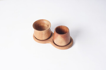 Two wooden cups are placed on a white background.