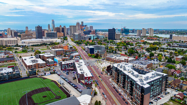 Downtown Detroit streets and skyline. Drone photo of downtown Detroit with city streets, buildings, and skyline under a blue sky.