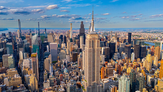 Empire State Building and Manhattan skyline aerial view. Aerial drone photo of the Empire State Building and Midtown Manhattan skyline during golden hour.