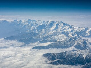 A breathtaking aerial view of snow-capped mountain peaks rising above a sea of clouds, showcasing the majestic beauty of high-altitude landscapes.