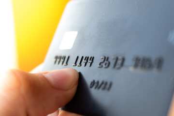 A close-up view of a black credit card with embossed numbers. The card is placed on a light surface, highlighting its sleek design and modern features.