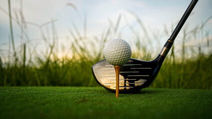 Golf ball on green grass in the evening golf course with sunshine background.