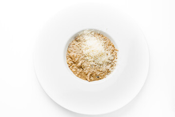 Creamy mushroom risotto served on a white plate, topped with finely grated cheese. Minimalist presentation, gourmet Italian cuisine, perfect for restaurant or food photography themes.