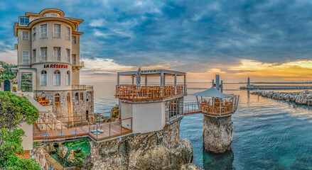 Coucher de soleil en bord de mer avec le restaurant atypique du plongeoir &agrave; Nice dans la baie des anges sur la C&ocirc;te d'Azur