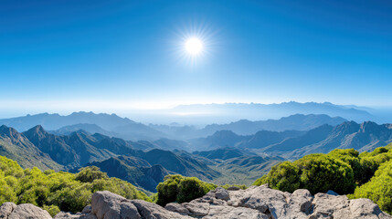 Breathtaking mountain landscape with sun shining over distant peaks, creating serene atmosphere