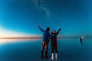 ボリビアウユニ塩湖の星空を見上げるカップル