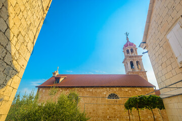 Photo of an old stone church in Sutivan showing traditional Dalmatian architecture, bell tower, cultural heritage details and Mediterranean charm in the historic heart of Brac Island