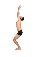 Man practices yoga by raising both arms up in a pose.