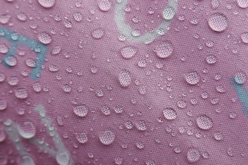 Refreshing water droplets cling to vibrant pink surface, showcasing fascinating texture and beautiful resilience of waterproof material after gentle shower. shimmering beads reflect light