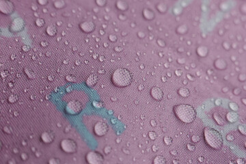 Refreshing water droplets cling to vibrant pink waterproof surface, creating beautiful texture. macro view highlights clean, clear beads, evoking sense of purity and calm with intricate detail