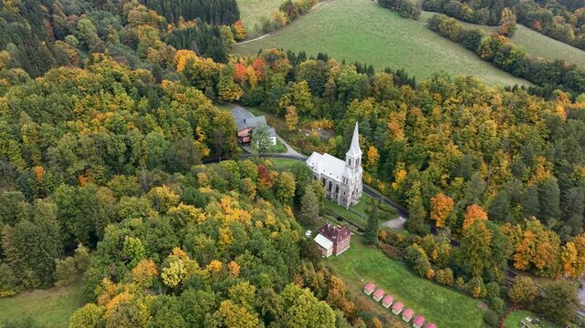 Aerial valley village church Travna Czechia autumn circle 2 4K. The Czech Republic or Czechia historically known as Bohemia. Central Europe. Autumn fall season, brilliant colorful leaves along roads.