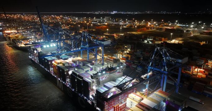 Unloading large cargo containers seaport. Loading freight sea port. Top aerial drone view. Lot big boxes rows, ship delivery ocean harbor. Shipping night. Goods export import. Industrial Marine dock.