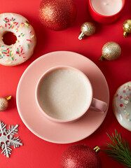 Creative concept photo of coffee cup with pastry and christmas decorations celebrating new year xmas holiday on red background.