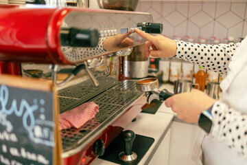 Barista preparing coffee in a coffee machine. Menu in Polish: Ice cream, strawberry, ricotta with elderberry
