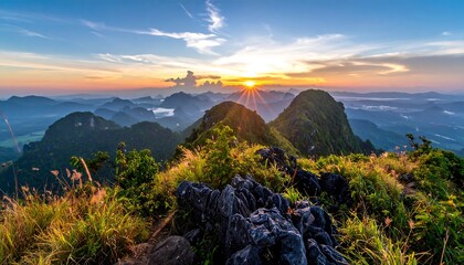 Majestic mountain range under a vibrant sunrise, showcasing dramatic light and shadow with lush greenery