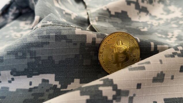 Gold bitcoin and soldier in military uniform