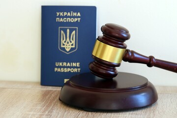 Judge hammer and ukrainian passport on brown background. Passport Of Ukraine. Obtain citizenship