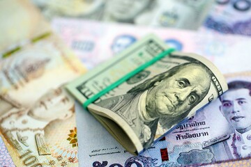 Thai baht currency money bills and bunch of us dollar banknotes close up. The concept of economics and currency exchange