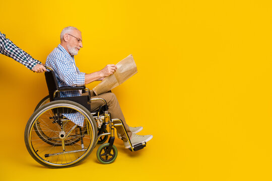 Funny wheelchair moment grandpa reads newspaper on bright yellow stage turning daily routine into cheerful adventure