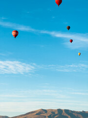 A hot air balloon flies over the city Yerevan, background of the blue sky. Aerial view of many colorful hot air balloons fly in the sky. High quality