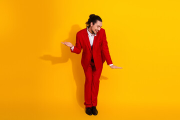 Funny stylish man in red suit dances on bright yellow backdrop creating a bold playful fashion moment for ads