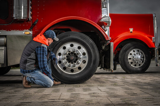 Truck Driver Inspects Tire at Service Location