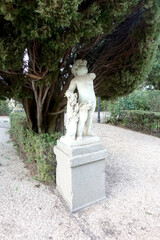 Obraz premium Statua di Putto nel Giardino di Castel Gandolfo sotto un Albero di Cipresso 4608