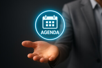 A hand holds an abstract glowing circular display featuring a calendar icon and the word "agenda," representing scheduling and future planning for meetings or events
