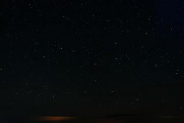 Fototapeta premium A long-exposure photo of the night sky showing streaks of stars forming short trails, creating a mesmerizing cosmic pattern in deep darkness.