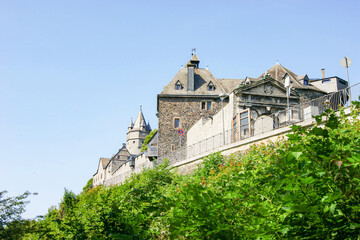 Fototapeta premium Scenic perspective of Altena Castle with surrounding greenery and blue sky. Concepts of fairytale destination, medieval heritage, Europe travel romance, historical monument, and cultural exploration.