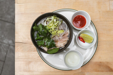 Vietnamese chicken pho with fresh herbs. Concept about tradition, culture and authentic cuisine.