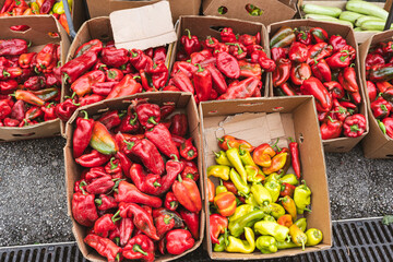 Boxes with red and green bell peppers at outdoor market. The image conveys the concept of sustainable farming and the abundance of fresh local produce for healthy living.