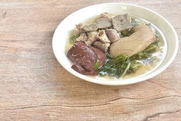 boiled pork blood and entrails with chop pork topping lettuce in soup on plate