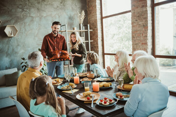 A lively Thanksgiving at home with family friends and generations gathered around a festive table...