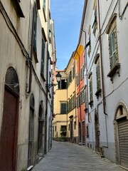 Pontremoli, Italy a small town in Tuscany.  Narrow street with colourful houses, antique street lamps, and a cobblestone street.  No people.