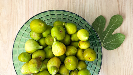 Lush green figs in a crystal bowl, invoking Mediterranean harvest festivals and the ancient Saturnalia's fruity abundance