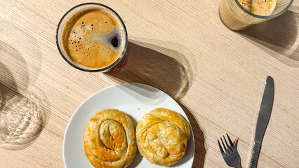 Golden spiral pastries paired with frothy espresso invite savory delight, echoing Greek Philoptochos celebrations and mid-morning rituals