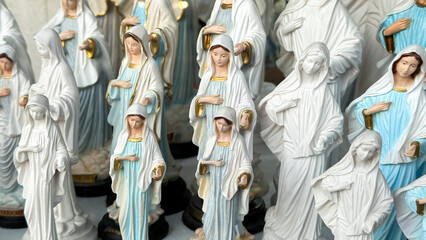 Ceramic saintly figures serenely clustered, evoking All Saints' Day reverence and curious whispers...