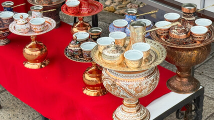 Ornate brass samovars cradle delicate tea cups on crimson cloth, echoing Persian Nowruz splendor and Turkish coffee traditions