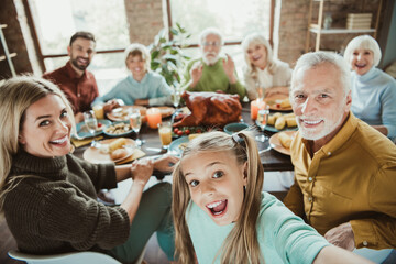funny festive family feast selfie as generations gather for a warm thanksgiving dinner and joyful holiday celebration around the big table