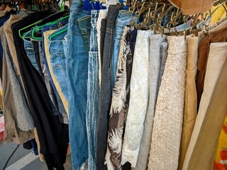 thrift store rack of used clothes and jeans
