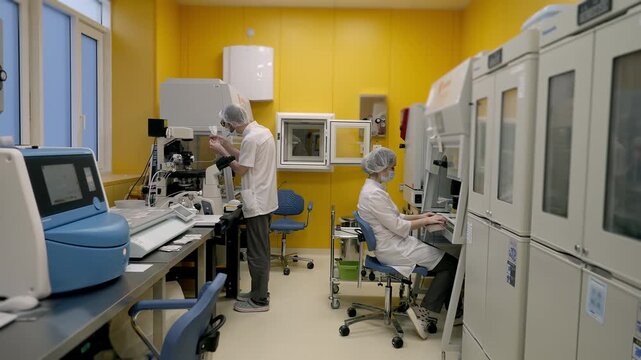 Doctors perform sample analysis at the modern medical test clinic. Medical specialists using testing equipment at the clinic. Medical professionals testing the embryos at the clinic.
