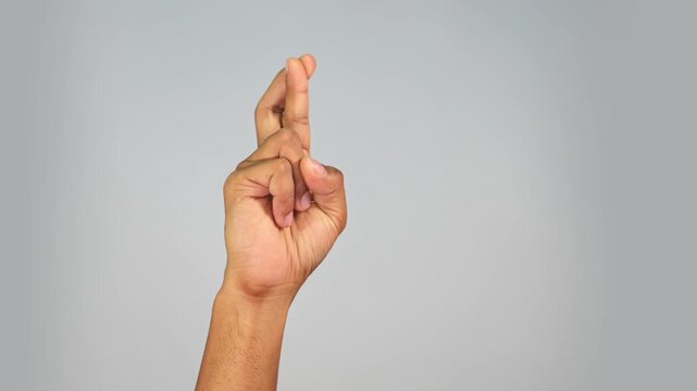 Hand Gesture Showing Good Luck Sign &mdash; Crossed Fingers Gesture on Studio Background