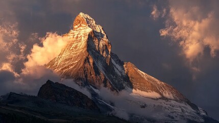 The majestic Matterhorn mountain peak illuminated by golden sunlight, surrounded by swirling clouds and rugged alpine terrain.
