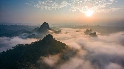 Sunrise Over Misty Mountains: A Serene Landscape of Peaks Emerging from Clouds