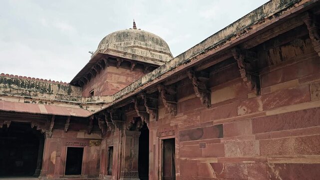 5th May 2025, Uttar Pradesh, India, Inner courtyard of Fatehpur Sikri palace complex featuring red sandstone walls, Mughal architecture, and ancient domed structure.