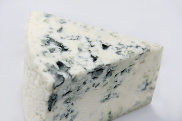 TOP SLICE OF FRACTIONATED BLUE CHEESE ON ISOLATED WHITE BACKGROUND