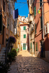 Rovinj, Croatia - August 15, 2025: Colorful Alley in Rovinj – a sunlit narrow street with hanging laundry, green shutters, and warm pastel walls typical of the coastal town of Rovinj, Croatia.