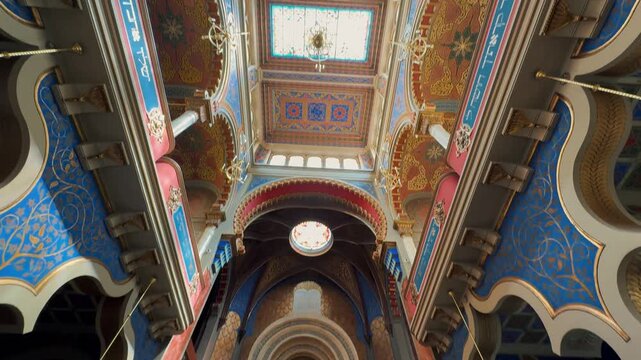 The opulent Neo-Moorish interior of the Spanish Synagogue in Prague, Czech Republic. Exquisite geometric patterns, vibrant colors, and elaborate gold ornamentation showcase 