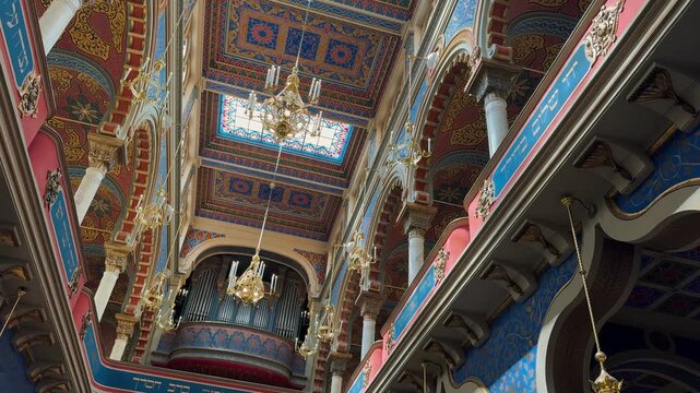 The opulent Neo-Moorish interior of the Spanish Synagogue in Prague, Czech Republic. Exquisite geometric patterns, vibrant colors, and elaborate gold ornamentation showcase 